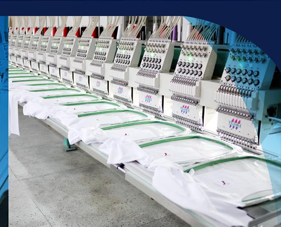 Hàng máy thêu công nghiệp đang thêu áo đồng phục trắng